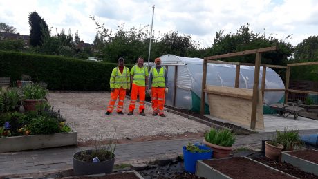 Three people in high vis work clothes standing in the Dorothy Parkes community allotment.