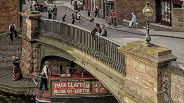 A barge going under a bridge on a canal in the Black Country Living Museum.