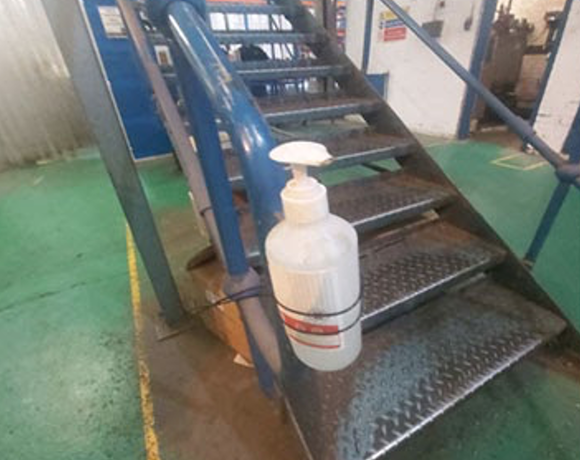 A bottle of hand sanitiser on the second step of an industrial metal staircase