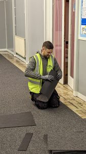 Builder in high visibility jacket fitting the new carpet