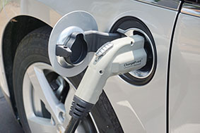 A close up of an electric car being charged