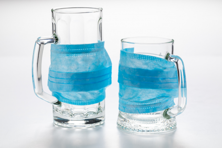 Two pub glasses with medical masks over them