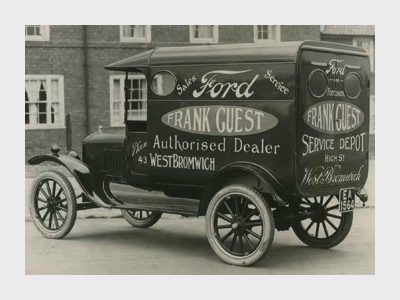 A black and white photo of a Frank Guest delivery van from the early 20th century