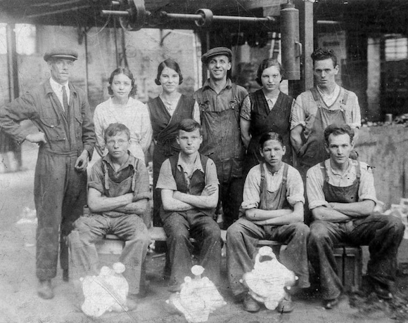 A black and white photo of 1920s foundry workers posing for the camera in two rows