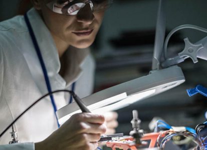 A close up of a scientist wearing protective goggles working in a lab