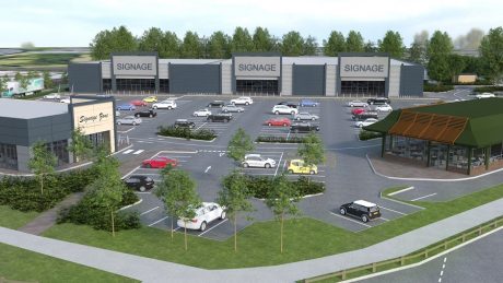 A computer generated image of a retail park with several units and cars parked in a car park in the centre with some trees around the outside.