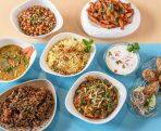 Bowls of different curries and rice and other Indian dishes on a table