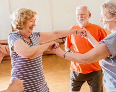 Three smiling people taking part in some kind of exercise class