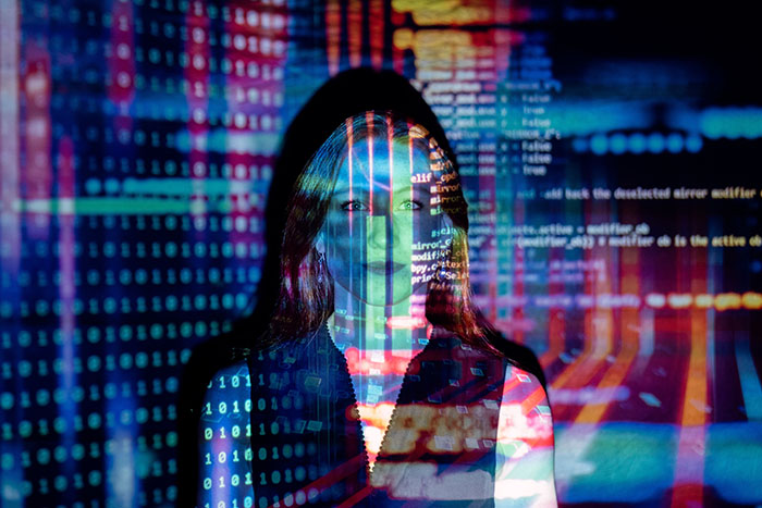 A woman with computer coding projected onto her and behind her