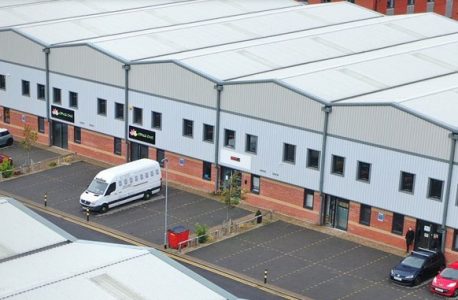 Industrial units at Phoenix Industrial Estate in West Bromwich with a white van and two cars parked outside in parking spaces