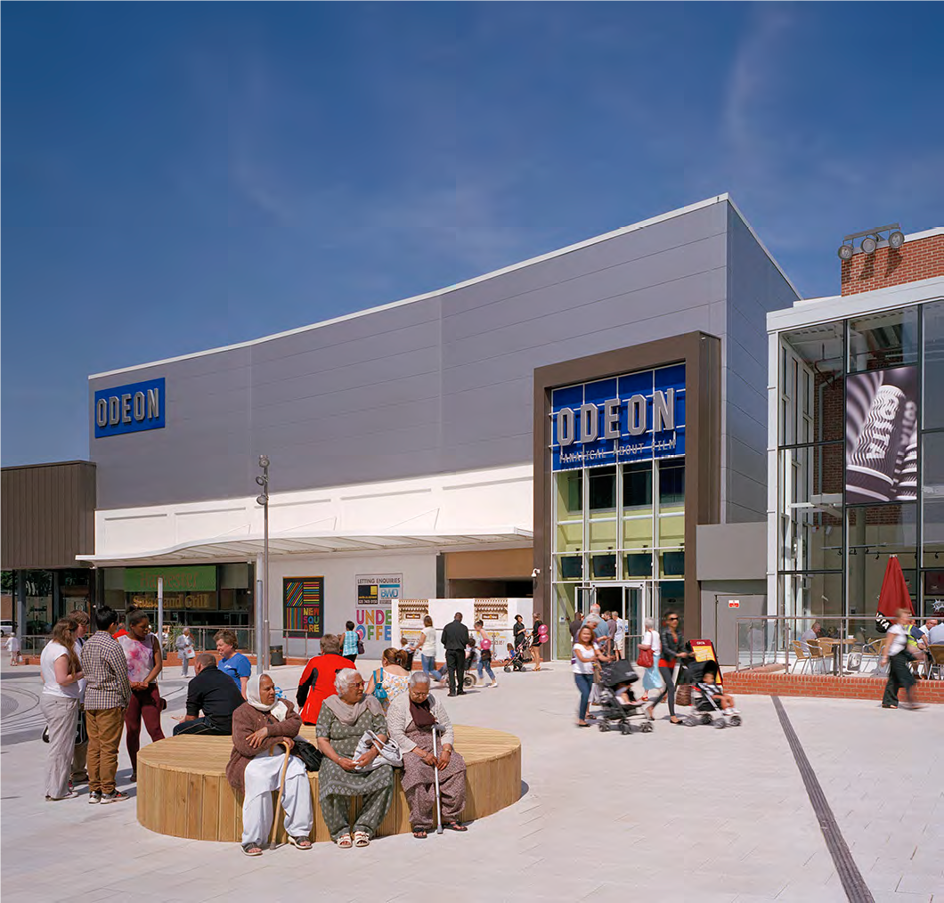 An Odeon cinema with people congregating outside it on a plaza.