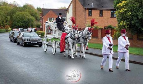 Ladies in white funeral team with a white cart and white horses