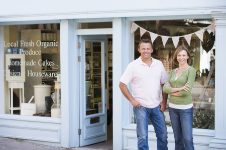 Couple standing in front of organic food store smiling