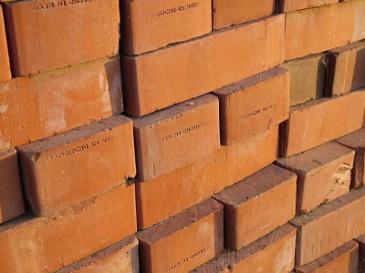 Close up image of a pile stacked red bricks