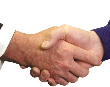 A close up of a handshake between two white men.