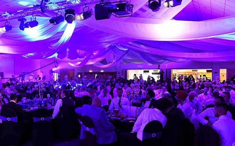A photo of the Nachural Business Ball - people seated at tables with purple lighting
