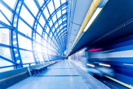 A blurred train speeding through a station with an empty platform.