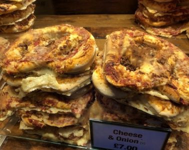 A pile of cheese and onion pretzels on a street food stall.